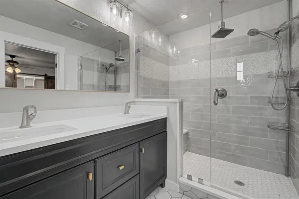 a bathroom with a shower sink and mirror