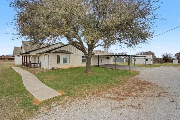 a view of a house with backyard and trees