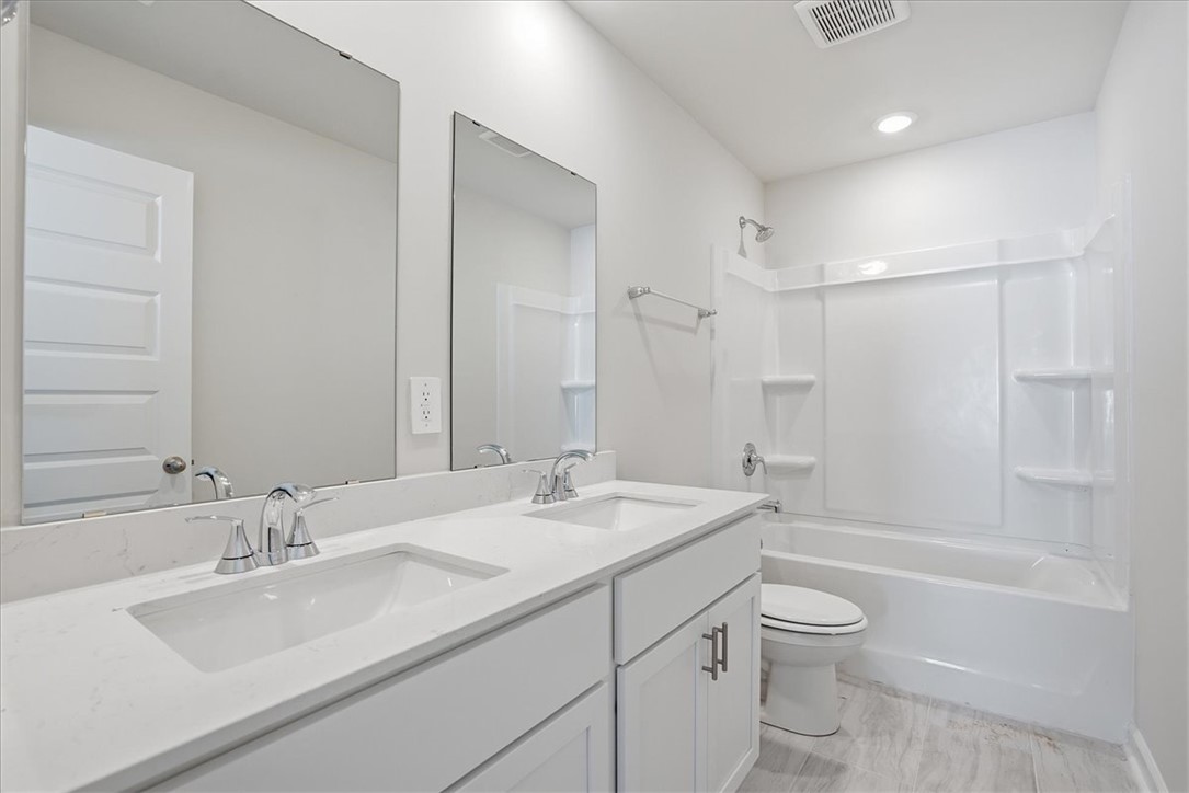 973 Penfold Pointe Point Blythewood, SC 29016 - Photo 25 of 39 Modern bathroom featuring a dual vanity and an integrated shower-tub combination.