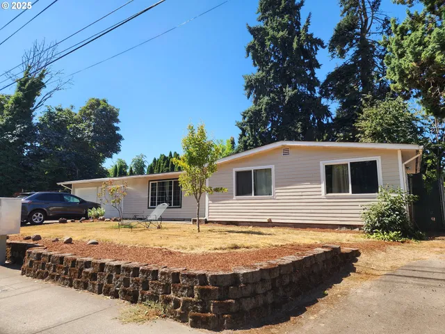 a view of a house with backyard and sitting area