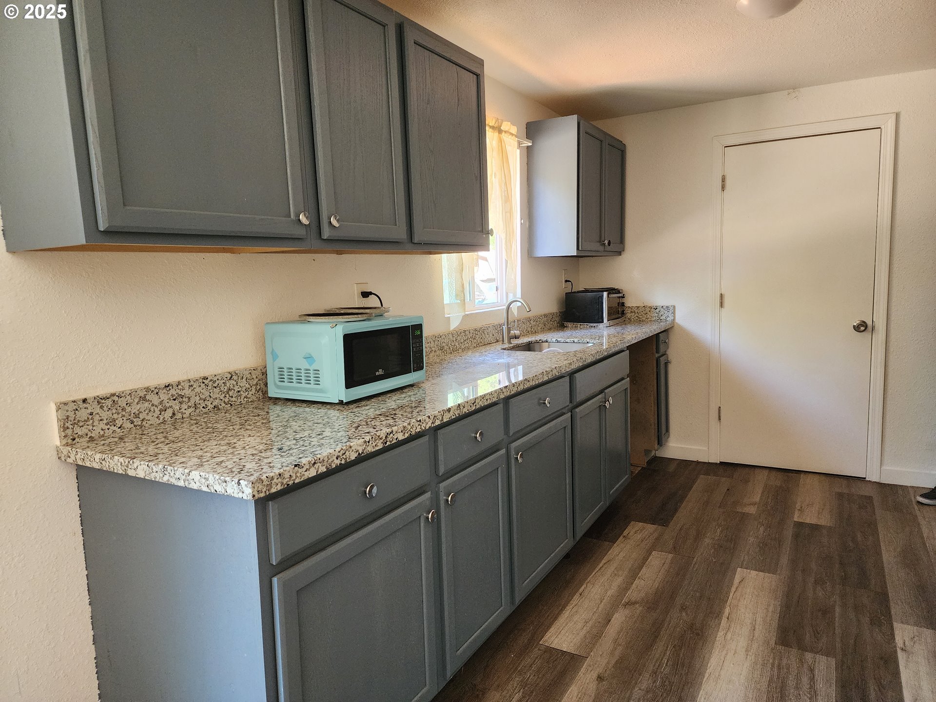 4061 Hawthorne Avenue Northeast Salem, OR 97301 - Photo 3 of 13 a kitchen with granite countertop a sink a stove and cabinets