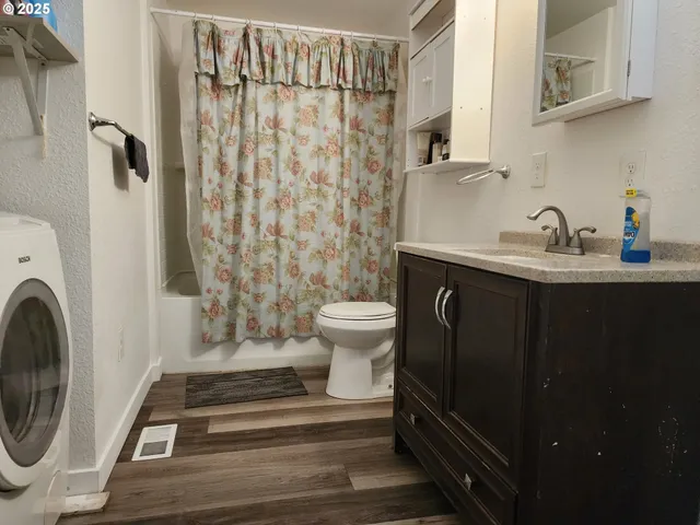 a bathroom with a sink a toilet and shower curtain