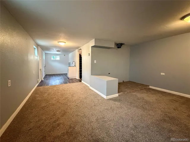 a kitchen with a sink and dishwasher with wooden floor
