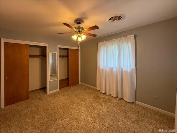 an empty room with closet and a window