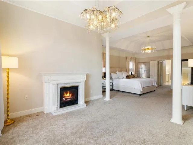 a spacious bedroom with a bed and a fireplace