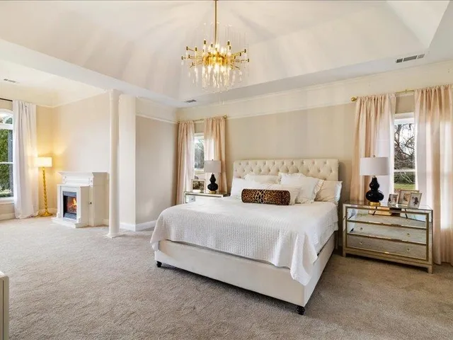 a bedroom with a bed and a chandelier