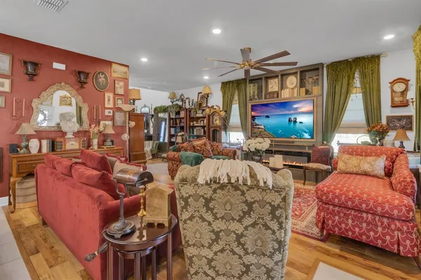 a living room with furniture a flat screen tv and a floor to ceiling window