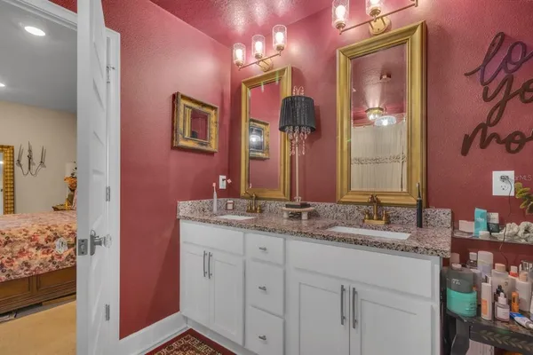 a bathroom with a granite countertop sink vanity and mirror