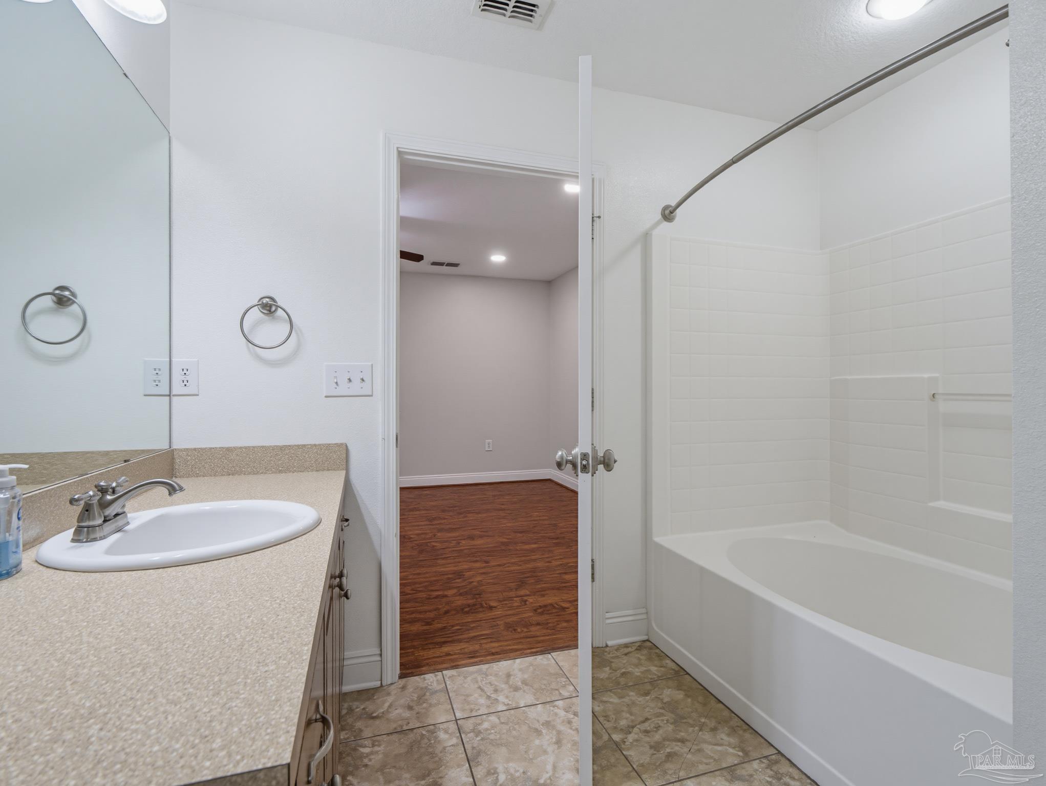 5567 Jones Street Milton, FL 32570 - Photo 30 of 48 a bathroom with a granite countertop sink and a bathtub