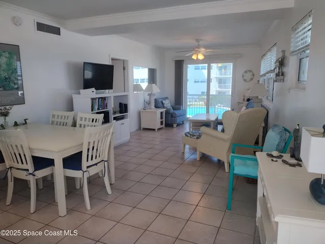 a dining room with furniture a flat screen tv and a window