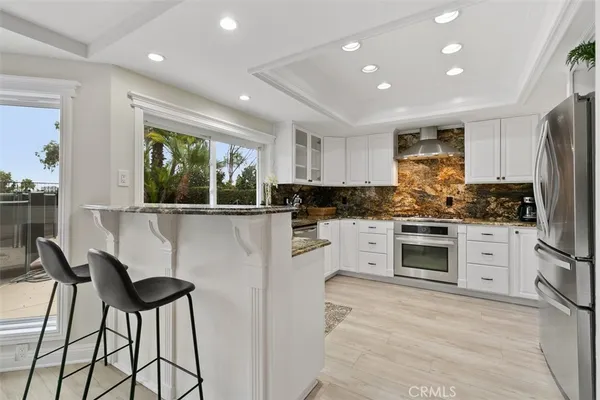 a kitchen with granite countertop white cabinets and stainless steel appliances