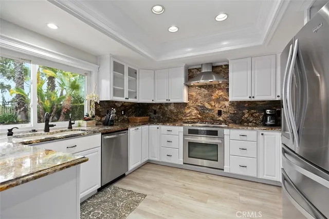 a kitchen with stainless steel appliances granite countertop a stove a sink and a refrigerator