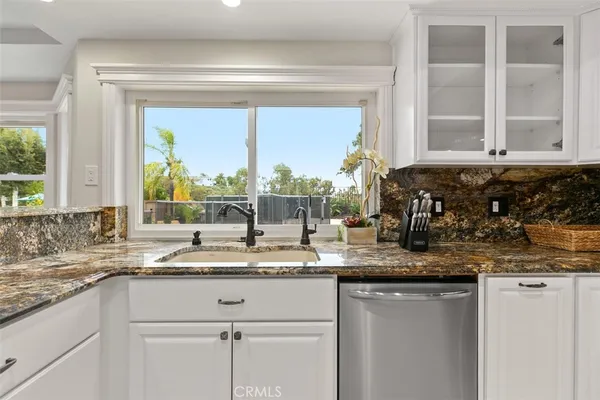 a kitchen with granite countertop a sink and a window