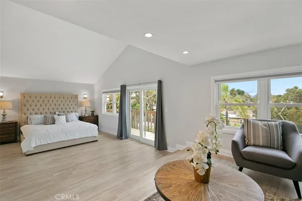 a bedroom with a large bed and wooden floor