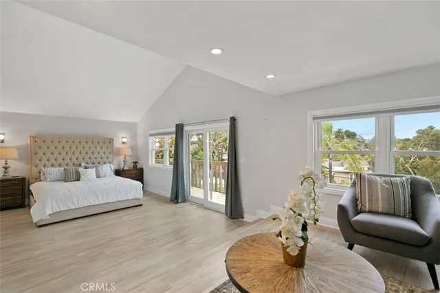 a bedroom with a large bed and wooden floor
