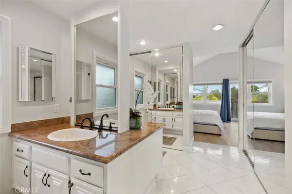 a bed sitting in a spacious bedroom next to a window