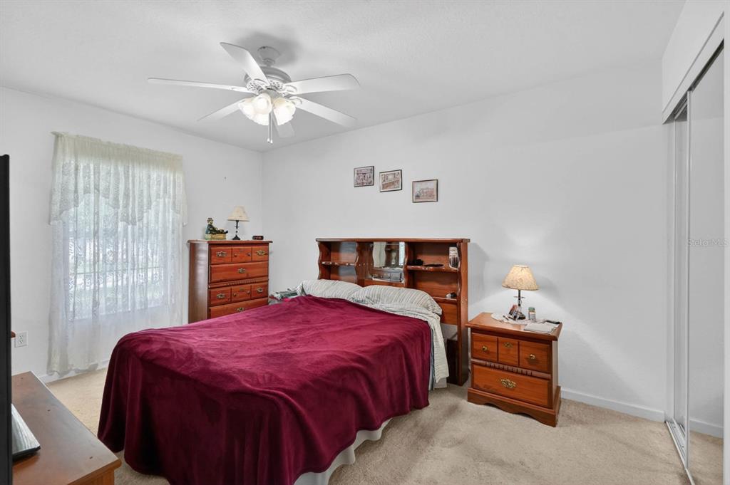 80 Roxboro Drive Palm Coast, FL 32164 - Photo 18 of 39 a bed sitting in a bedroom next to a window and a chandelier
