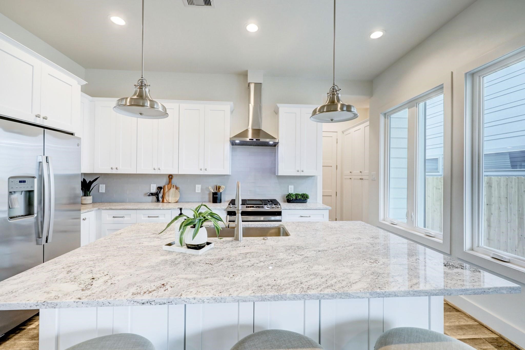 3827 Arlington Street Houston, TX 77018 - Photo 11 of 39 Spacious island with pendant lighting. Large windows provide ample natural light, creating a bright and inviting space.