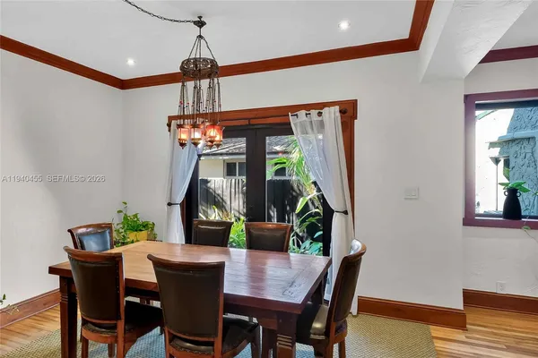 a dining room with furniture potted plants and wooden floor