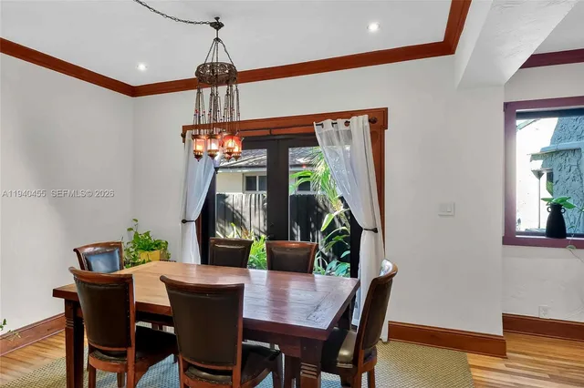 a dining room with furniture potted plants and wooden floor