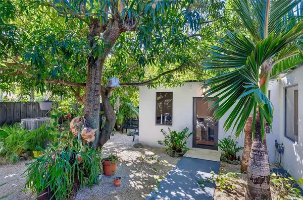 a backyard of a house with a garden and outdoor seating