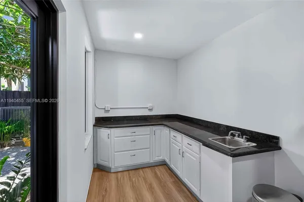 a kitchen with granite countertop white cabinets and white appliances