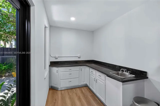 a kitchen with granite countertop white cabinets and white appliances