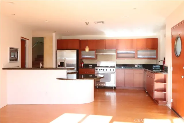 a kitchen with stainless steel appliances a large counter top a stove and a refrigerator