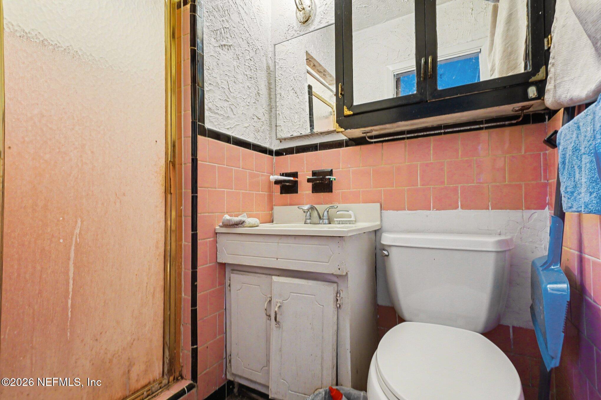 1826 Leon Road Jacksonville, FL 32246 - Photo 19 of 23 a bathroom with a toilet a sink and a mirror