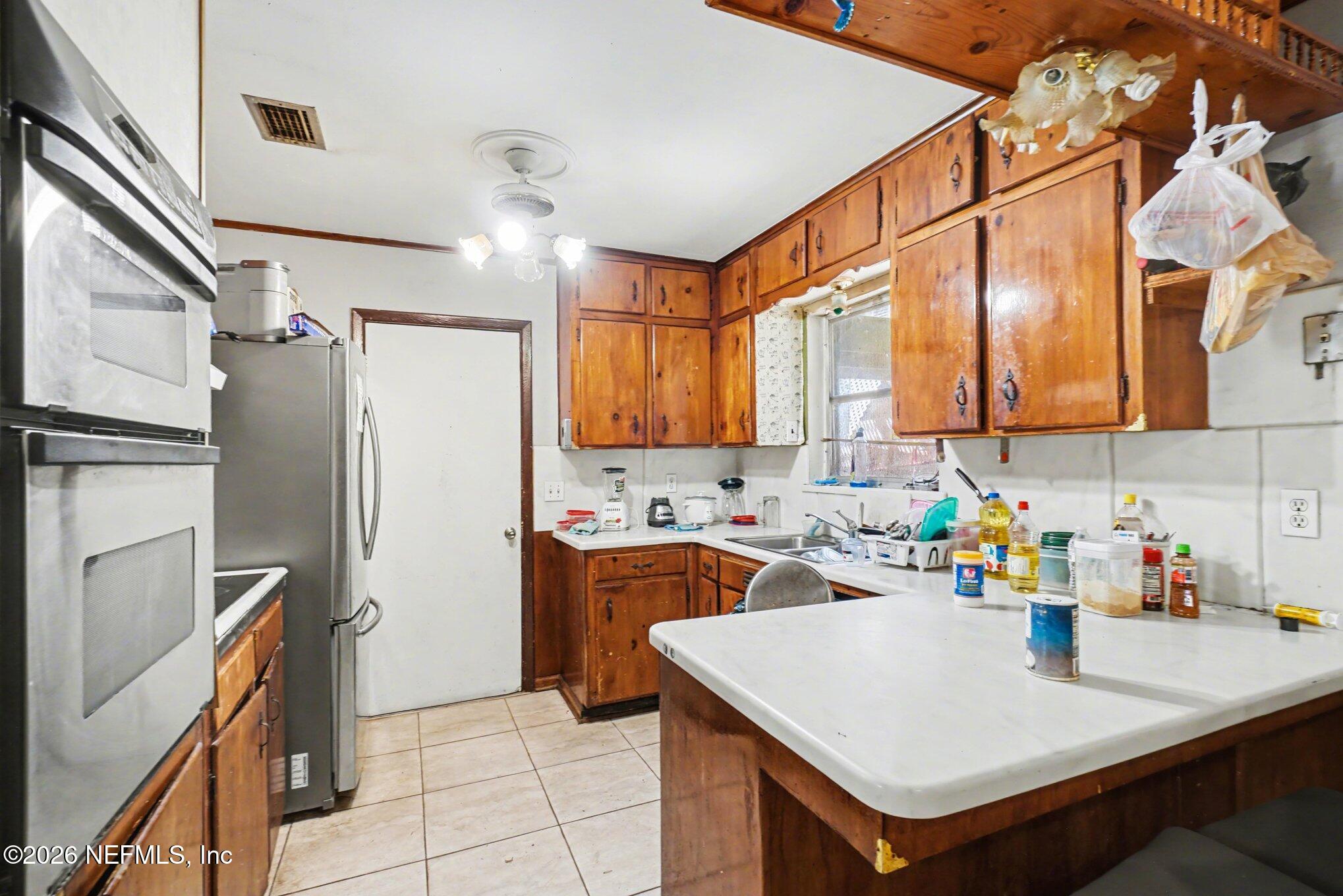 1826 Leon Road Jacksonville, FL 32246 - Photo 7 of 23 a kitchen with a sink a refrigerator and cabinets