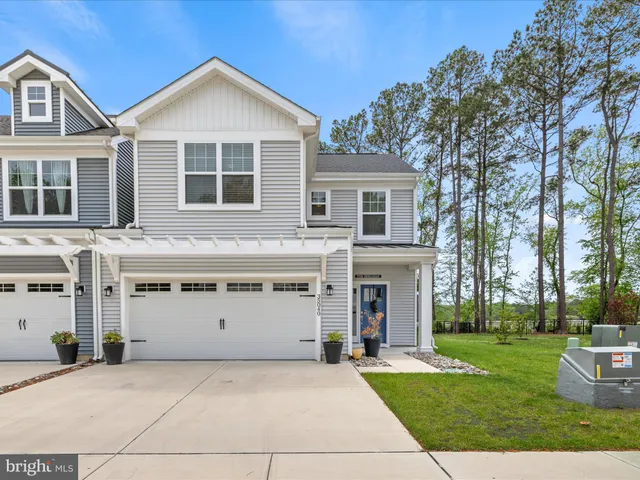 a front view of a house with a yard and trees