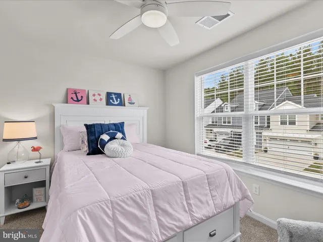 a bedroom with a bed and a refrigerator