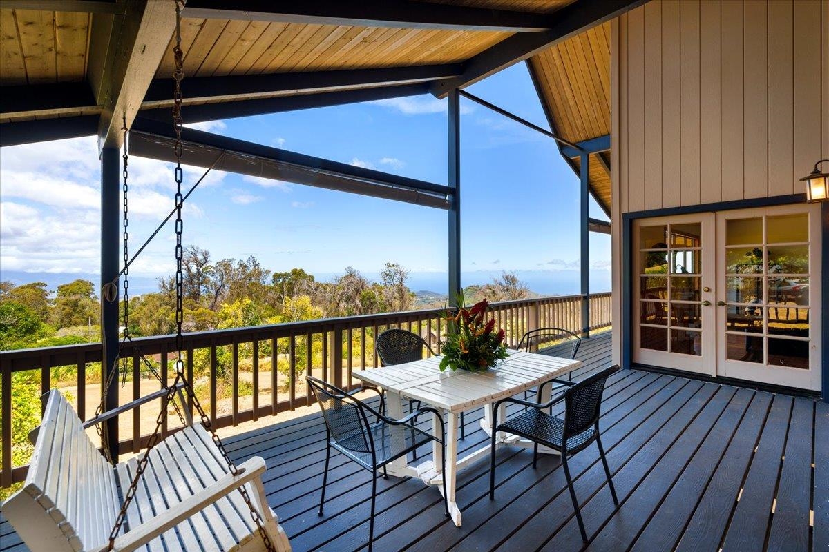 a view of a balcony with wooden floor and outdoor seating