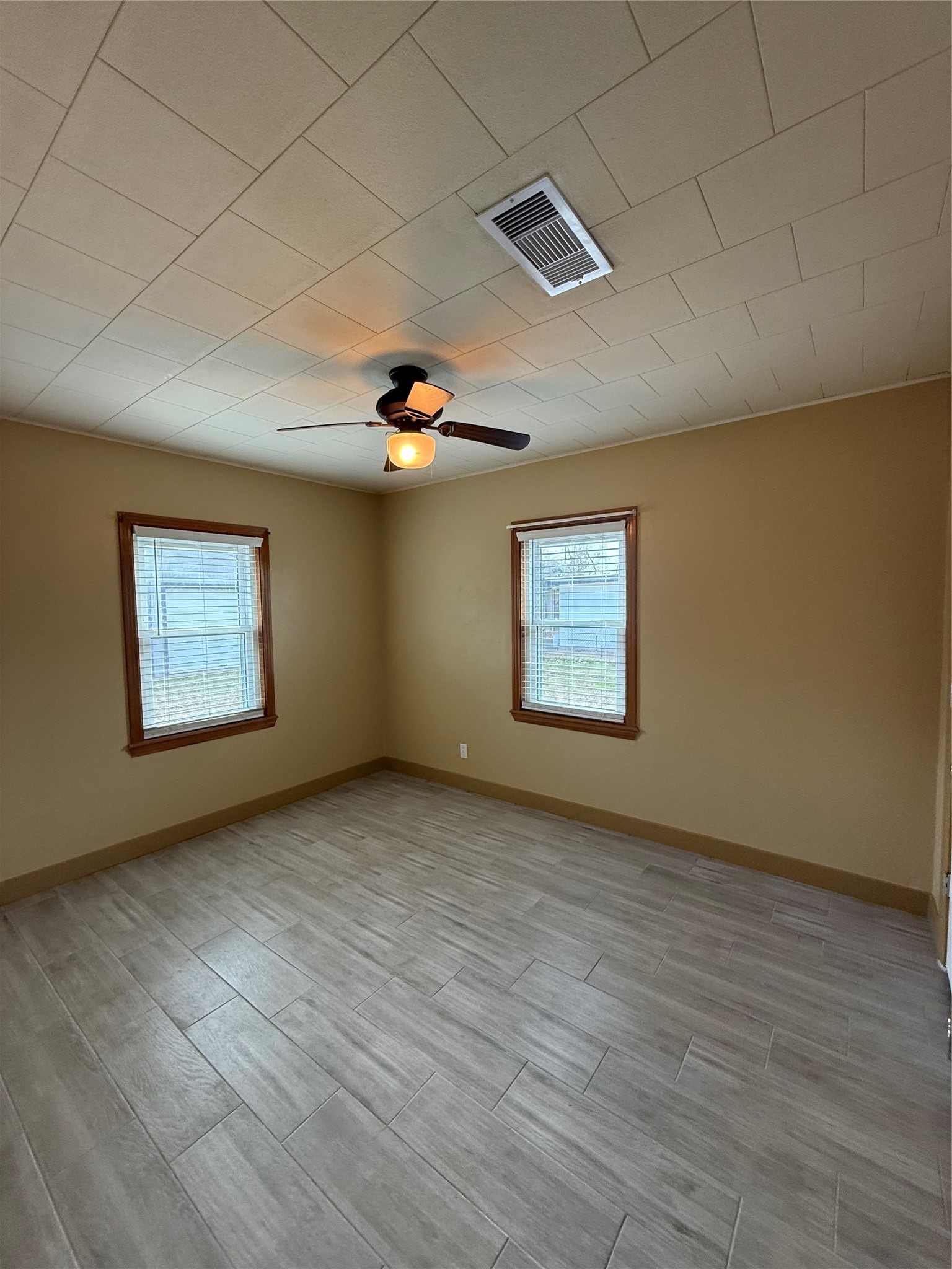 706 Alice Street Sweeny, TX 77480 - Photo 5 of 8 an empty room with wooden floor and windows