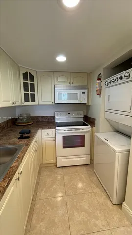 an empty room with a chandelier fan and a bathroom