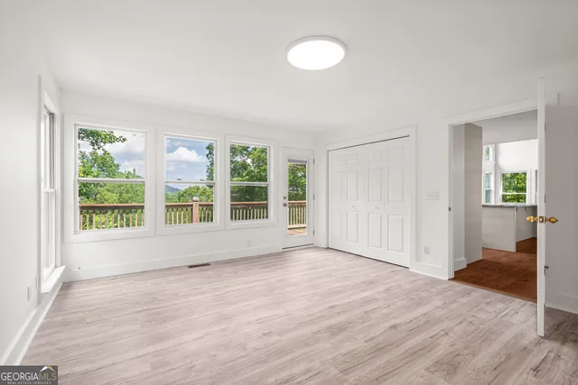 a view of an empty room with wooden floor
