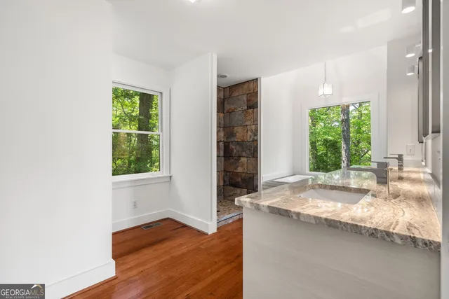 a bathroom with a granite countertop sink and a large mirror