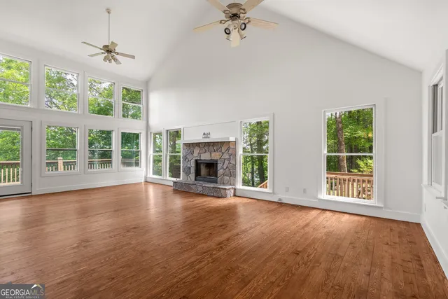 a view of an empty room with a window and wooden floor