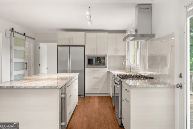 a kitchen with granite countertop a sink stove and refrigerator