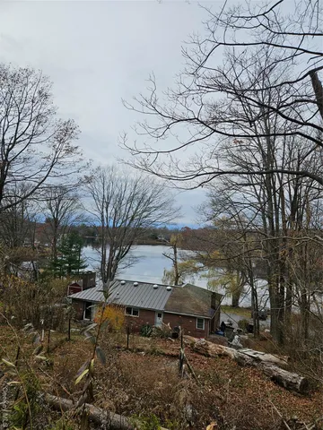 a backyard of a house with table and chairs under an umbrella