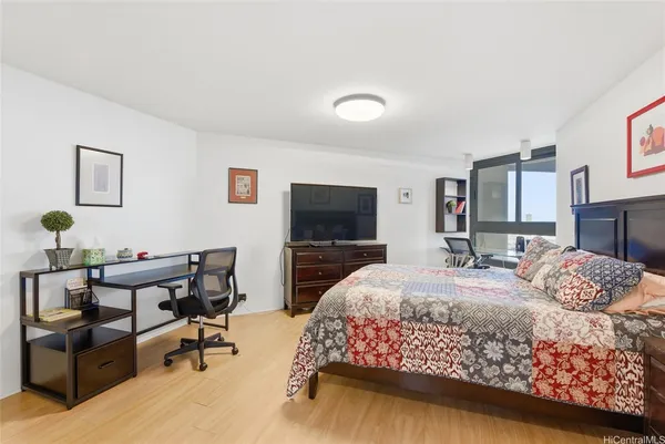 a bedroom with a bed and a flat screen tv