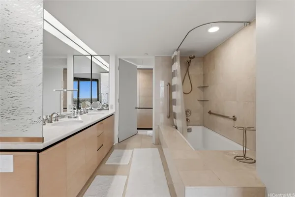 a bathroom with a tub sink shower and mirror