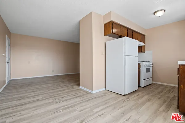 a view of a kitchen with wooden floor and electronic appliances