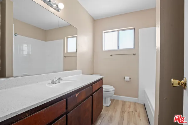 a bathroom with a sink a toilet and a mirror