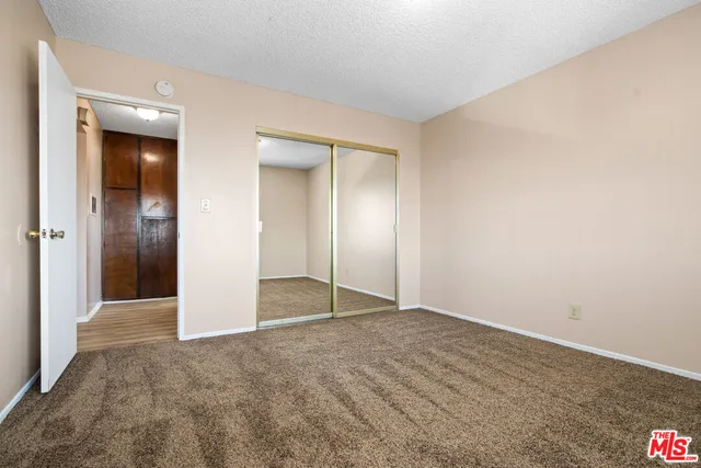 an empty room with closet and mirror