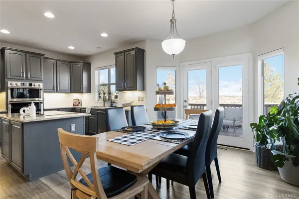 a kitchen with kitchen island granite countertop wooden floor dining table and chairs