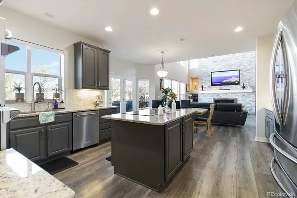 a kitchen with stainless steel appliances granite countertop a sink a stove and a refrigerator