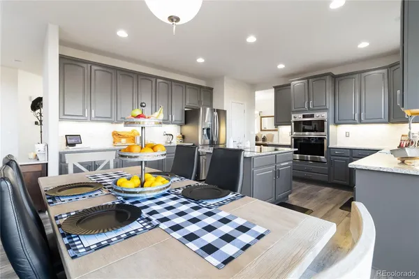 a kitchen with a refrigerator and a stove top oven