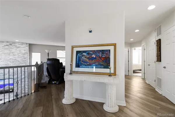 a view of a hallway with wooden floor and furniture