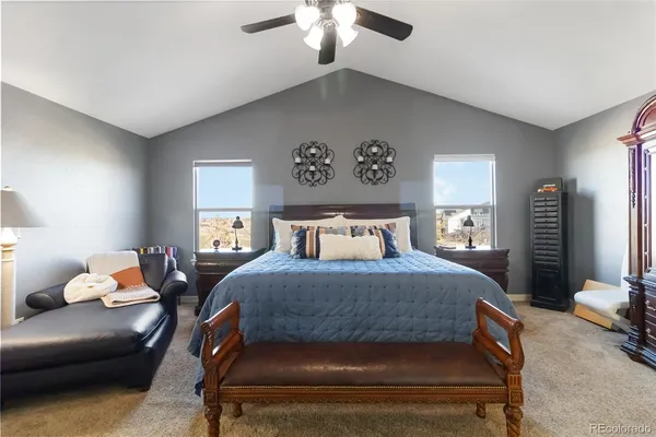 a bedroom with a bed couch chandelier and a window